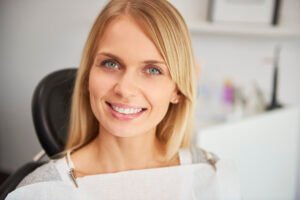 portrait of pleased and smiling woman in dentist's clinic